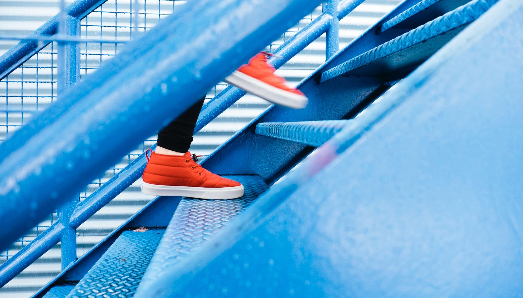 A photo of someone climbing up blue stairs